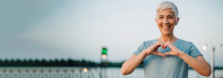 A woman making a heart shape with her hands.